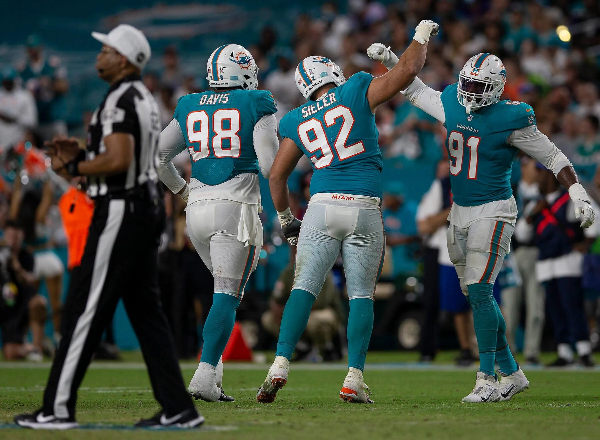 Miami Dolphins defensive end Zach Sieler (92) and teammate Miami Dolphins defensive end Emmanuel Ogbah (91) celebrate against the Baltimore Ravens during NFL game at Hard Rock Stadium Thursday in Miami Gardens. Baltimore Ravens V Miami Dolphins 038